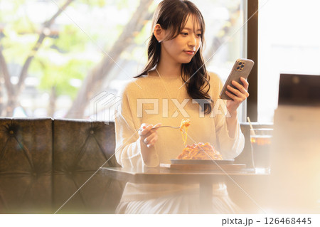 カフェでスマホを見る若い女性 126468445