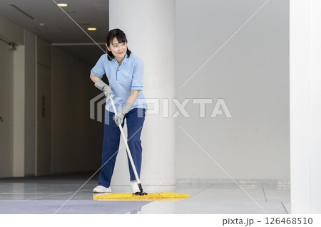 ビル清掃イメージ　フロアのモップかけをする50代の女性清掃スタッフ 126468510