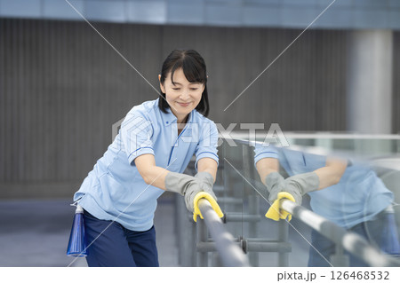 ビル清掃イメージ　通路の手すりを拭く50代の女性清掃スタッフ 126468532