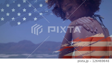 Woman on beach with American flag image over mountains and ocean background 126469648