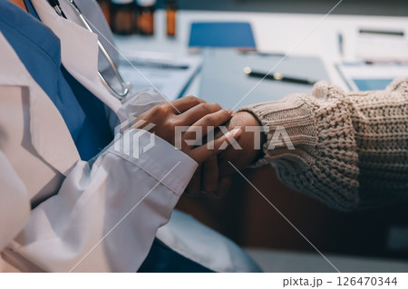 Medicine doctor hand reassuring her female patient Medicine doctor hand reassuring her female patient 126470344