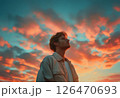 男性の横顔と夕焼けの空の背景　AI生成素材 126470693