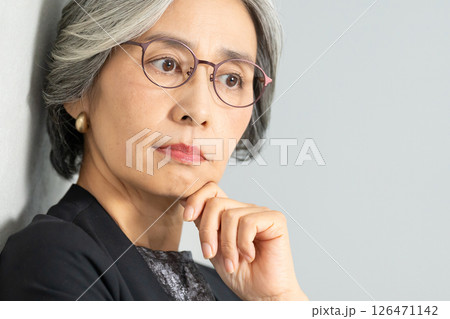 顎に手を当てて考えるシニア女性 126471142