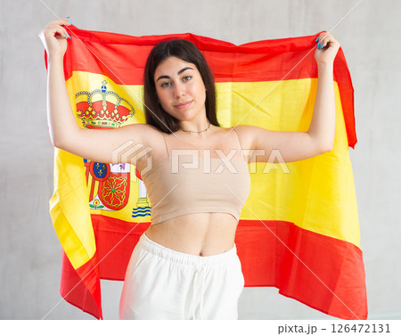 Young woman with flag of Spain posing in studio 126472131