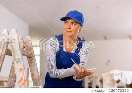 Portrait of a woman engineer making notes on paper Portrait of a woman engineer making notes on paper 126472389