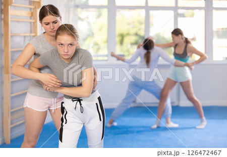 Two teenage girls training in group self defense classes Two teenage girls training in group self defense classes 126472467