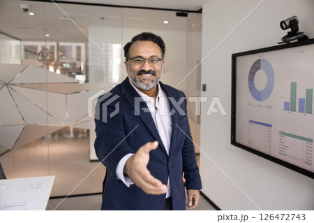 Indian businessman in formal suit extending his arm for handshake Indian businessman in formal suit extending his arm for handshake 126472743