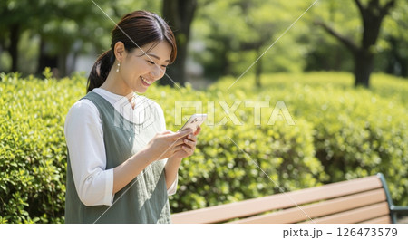 スマートフォンを使う若い女性(屋外) スマートフォンを使う若い女性(屋外) 126473579