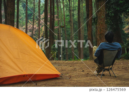 solo traveler in nature concept with asian man camping and see pink cherry blossom tree and pine tree with sunrise in springtime season solo traveler in nature concept with asian man camping and see pink cherry blossom tree and pine tree with sunrise in springtime season 126475569