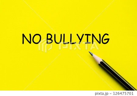 No bullying text on yellow pad with pen representing efforts to foster a supportive and respectful culture No bullying text on yellow pad with pen representing efforts to foster a supportive and respectful culture 126475701