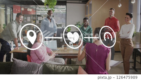 Image of media icons over diverse colleagues discussing work in office 126475989