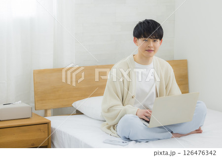 ベッドでノートパソコンを操作する男性 ベッドでノートパソコンを操作する男性 126476342