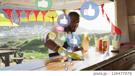 Cleaning counter, man surrounded by floating thumbs-up icons in image 126477078
