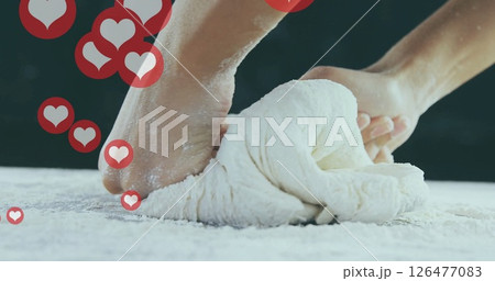 Kneading dough with heart icons image over hands on floured surface 126477083