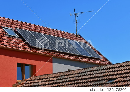 Family house with solar panels on the roof. Home photovoltaic power plant. Concept for industry and green cheaper electricity from renewable sources. Family house with solar panels on the roof. Home photovoltaic power plant. Concept for industry and green cheaper electricity from renewable sources. 126478202