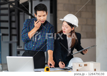Businessman working as a team discussing data working and tablet, laptop with on on architectural project at construction site. 126479130