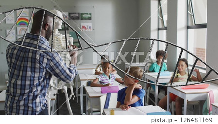 Image of dna strand over diverse male teacher and schoolchildren in classroom Image of dna strand over diverse male teacher and schoolchildren in classroom 126481169