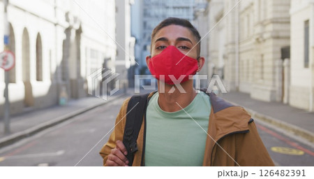 Biracial man wearing face mask, turning around in the street Biracial man wearing face mask, turning around in the street 126482391