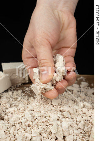 Crumbling Moist Yeast Block by Hand Close-Up. Crumbling Moist Yeast Block by Hand Close-Up. 126483313