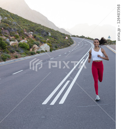 Woman running on open road in nature, enjoying outdoor fitness activity, copy space Woman running on open road in nature, enjoying outdoor fitness activity, copy space 126483568