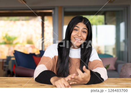 Smiling Indian teenager at home, engaging in conversation with expressive gestures Smiling Indian teenager at home, engaging in conversation with expressive gestures 126483700