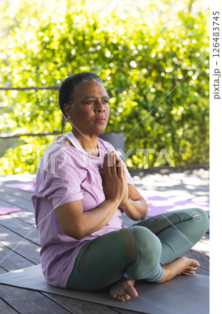 African American woman meditating on yoga mat outdoors, embracing tranquility African American woman meditating on yoga mat outdoors, embracing tranquility 126483745