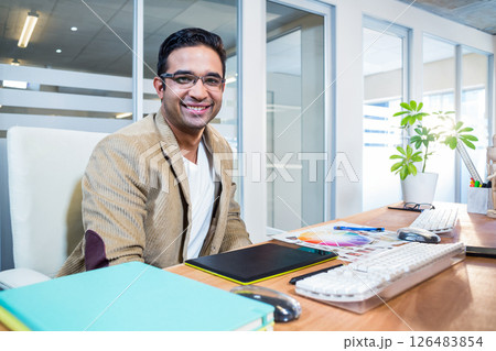 In office, businessman using tablet and keyboard, feeling confident and relaxed 126483854