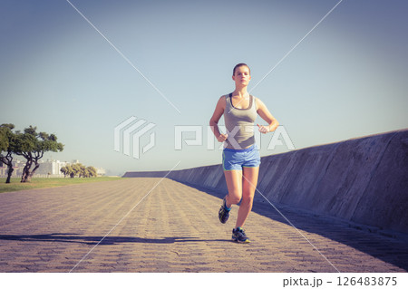 Woman jogging on sunny promenade, embracing fitness and healthy lifestyle outdoors, copy space Woman jogging on sunny promenade, embracing fitness and healthy lifestyle outdoors, copy space 126483875