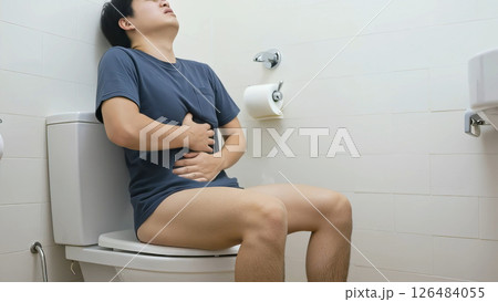 トイレで腹痛の激しい痛みを堪える、Tシャツ姿の男性 トイレで腹痛の激しい痛みを堪える、Tシャツ姿の男性 126484055