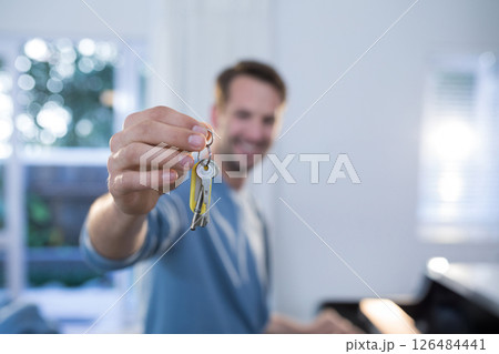 Smiling man holding keys in bright living room, celebrating new home, copy space Smiling man holding keys in bright living room, celebrating new home, copy space 126484441