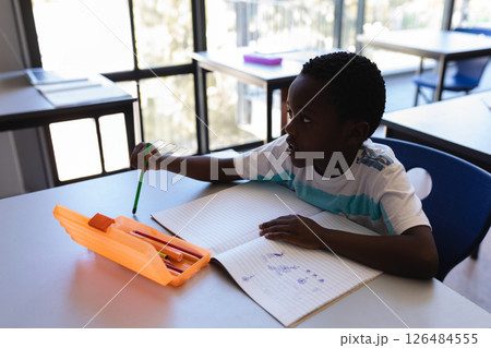 In school, young boy drawing in notebook, concentrating on creative work, copy space In school, young boy drawing in notebook, concentrating on creative work, copy space 126484555