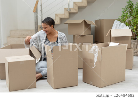 Smiling woman unpacking cardboard boxes at home, enjoying new living space, copy space Smiling woman unpacking cardboard boxes at home, enjoying new living space, copy space 126484682