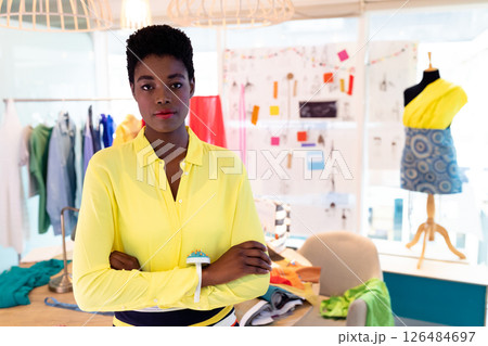 Fashion designer in bright yellow shirt standing confidently in creative studio, copy space 126484697