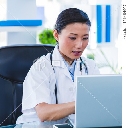 Doctor using laptop in office, focused on medical research and documentation Doctor using laptop in office, focused on medical research and documentation 126484907
