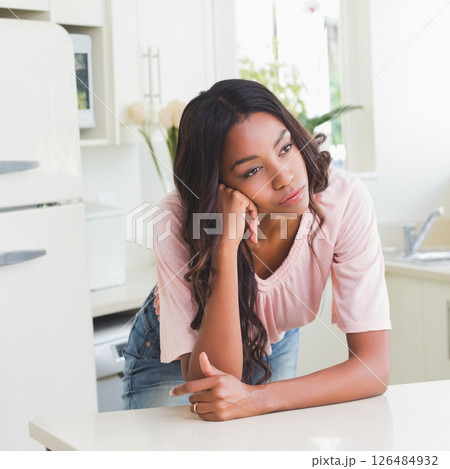 Woman leaning on kitchen counter, daydreaming in bright, modern kitchen Woman leaning on kitchen counter, daydreaming in bright, modern kitchen 126484932