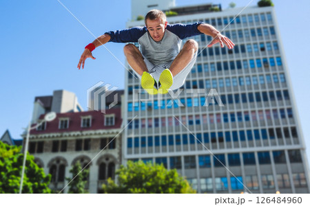 Man performing parkour jump in city, showcasing urban fitness and agility, copy space Man performing parkour jump in city, showcasing urban fitness and agility, copy space 126484960