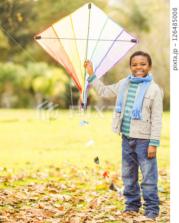 Smiling African American boy holding colorful kite in autumn park, copy space 126485008