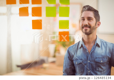 Businessman brainstorming with sticky notes on glass in modern office, copy space 126485134