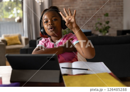 In school, child learning online at home, wearing headphones, raising hand, copy space 126485288