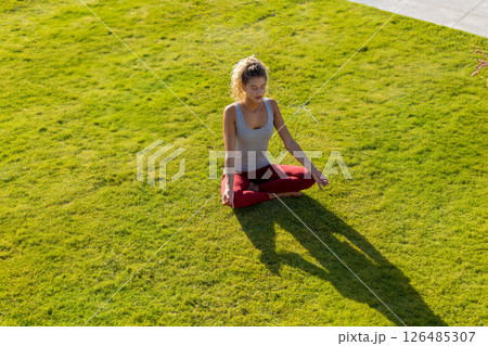 Woman meditating on grass, enjoying peaceful moment in outdoor setting, copy space Woman meditating on grass, enjoying peaceful moment in outdoor setting, copy space 126485307