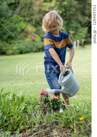 Young boy watering garden plants with watering can in backyard, copy space 126485351