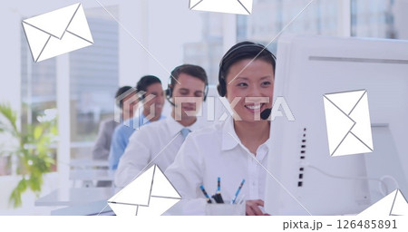 Digital composite of an asian female call centre agent typing with message icons in the foreground 126485891