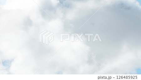 Fluffy white clouds floating in bright blue sky on sunny day Fluffy white clouds floating in bright blue sky on sunny day 126485925