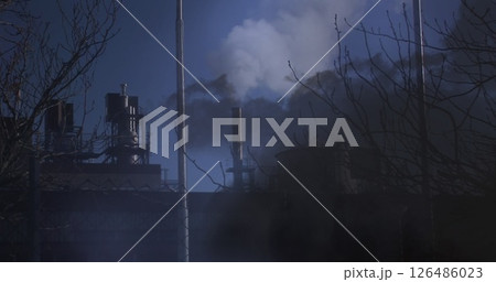 Emitting smoke, factory chimneys against dark sky, highlighting pollution problem 126486023