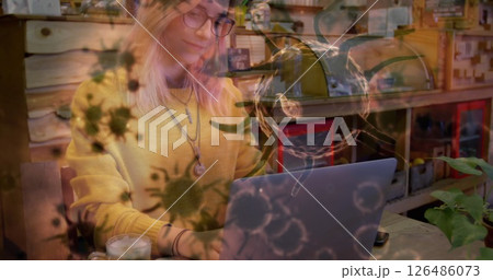 Young woman using laptop in cozy cafe, surrounded by virus illustrations 126486073