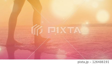 Person walking along beach at sunset, enjoying peaceful ocean waves 126486191