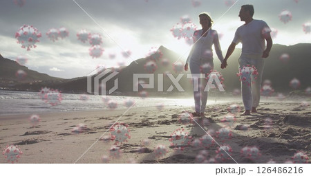Image of cells floating over caucasian couple walking on a beach, holding hands 126486216