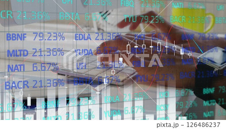 Analyzing financial data on computer with stock market graphs overlaying screen Analyzing financial data on computer with stock market graphs overlaying screen 126486237