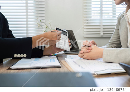 Financial Strategy Meeting. Professional discussing financial plans with a client using a calculator. 126486784