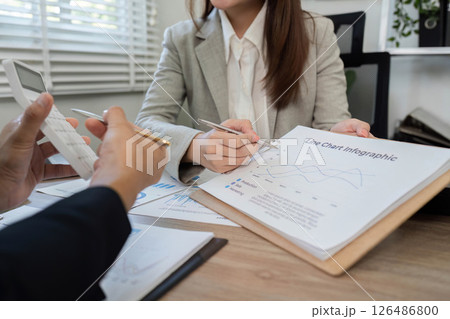 Financial Analysis Meeting. Professionals reviewing charts and financial documents with calculator. Financial Analysis Meeting. Professionals reviewing charts and financial documents with calculator. 126486800